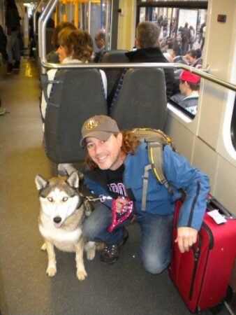 Man and husky dog on a train.