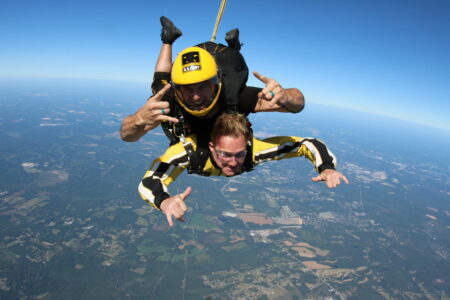 Two men mid-air while skydiving.