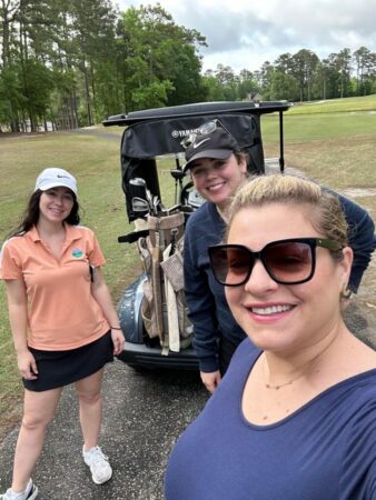 3 women playing golf.
