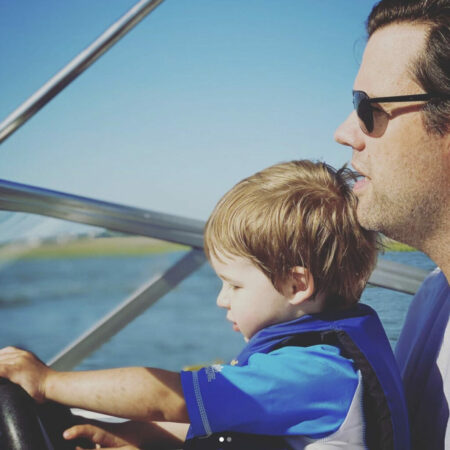 Father and son driving a boat.