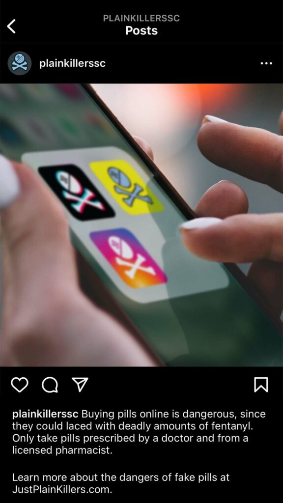 Social post on phone with skull and cross bones