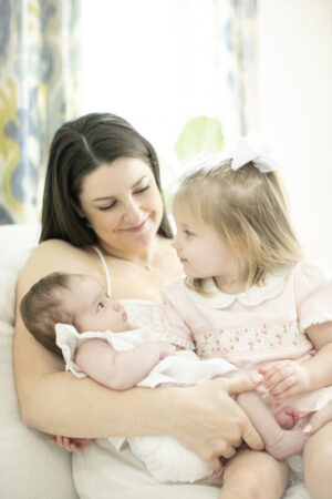 Women and man with a baby all smiling outside