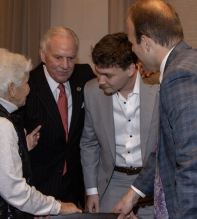 a group of men and women leaned in during a conversation