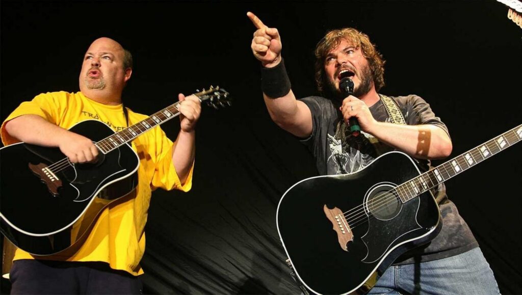Tenacious D band two men hold guitars on stage